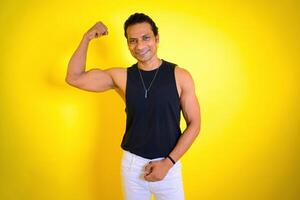 Man in black tank top flexing muscles photo