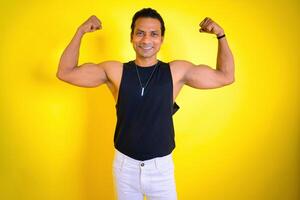 Man in black tank top flexing muscles photo