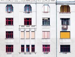 Facade of a building with red window frames of different shapes photo