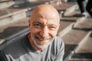 Smiling elderly man enjoying the day outside in a city environment, casual and relaxed photo