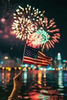 Hand holds an American flag with firework photo