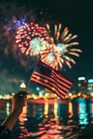 Hand holding American flag with fireworks photo