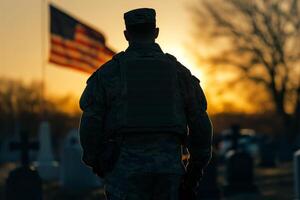 Military man seen from back, standing in cemetery photo