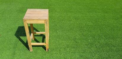 Wooden chair putting on green grass field with copy space. Wood material, Single object and Green natural concept. photo