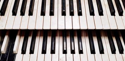 Close up pattern of old or dirty piano keyboard for background. Object, Art, Music and Instrument concept. photo