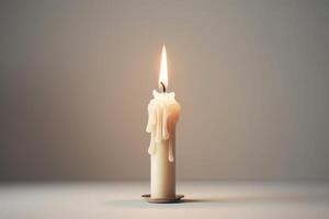 White small candle on white background. The fire is burning. Wax flows. Metal stand for candle. White floor and wall. photo