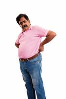 A middle aged Indian man with back pain isolated on a white background photo