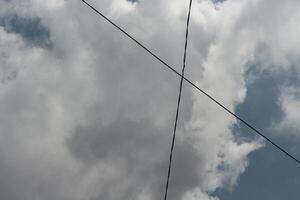 Cloudy sky with intersecting power lines photo