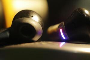 Close-up of wireless earbuds with LED light photo