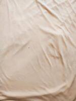 texture and background of wrinkled cream fabric photo