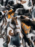 The fabric is patterned with a dense arrangement of blooming floral motifs in medium tones photo