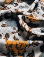 The fabric is patterned with a dense arrangement of blooming floral motifs in medium tones photo