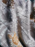 Fragments of colorful textile patterns with floral ornaments are useful as a background photo