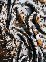 The fabric is patterned with a dense arrangement of blooming floral motifs in medium tones photo