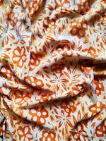The fabric is patterned with a dense arrangement of blooming floral motifs in medium tones photo