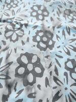 The fabric is patterned with a dense arrangement of blooming floral motifs in medium tones photo