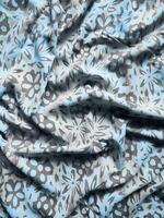 The fabric is patterned with a dense arrangement of blooming floral motifs in medium tones photo