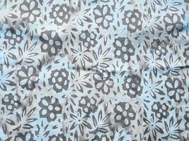 The fabric is patterned with a dense arrangement of blooming floral motifs in medium tones photo