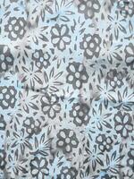The fabric is patterned with a dense arrangement of blooming floral motifs in medium tones photo