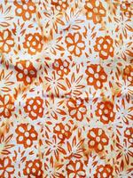 The fabric is patterned with a dense arrangement of blooming floral motifs in medium tones photo