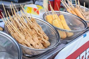 The tofu is cut thinly and skewered using bamboo, then fried and sold at culinary festivals photo