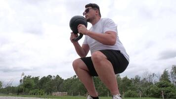 sports and leisure. strong Caucasian man working out using kettlebell in the park video