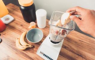 pov making a smoothie with apple and supplements nutritions. photo