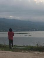 A Man Enjoys the Evening Atmosphere on the Edge of Lake Limboto, Gorontalo photo