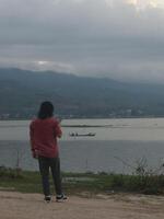 A Man Enjoys the Evening Atmosphere on the Edge of Lake Limboto, Gorontalo photo