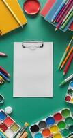 School vertical green background with pen, pencil, notepad, book, paints, crayons. Stationery around empty space. Back to School Advertising photo