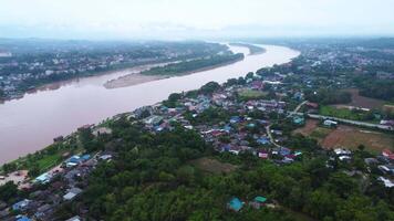 Aerial view of the mighty Mekong River winding from Chiang Khong, showing the vastness and beauty of the muddy waterway contrasting with the surrounding lush mountains and Laos villages. video