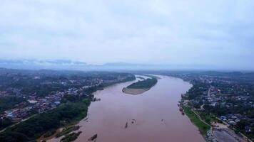 Aerial view of the mighty Mekong River winding from Chiang Khong, showing the vastness and beauty of the muddy waterway contrasting with the surrounding lush mountains and Laos villages. video