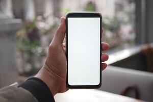 A hand holds a smartphone with a blank screen, suitable for app or website mockups photo