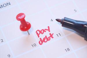 close up of pay debt word on calendar. photo