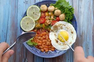 Start your day with a vibrant Rustic Breakfast of veggies, beans, and eggs in a delightful bowl photo