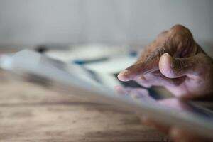Hand using digital tablet with touch screen browsing internet and interacting with modern technology photo