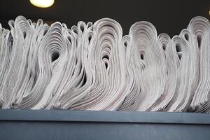 Pile of newspapers stacks on table . photo