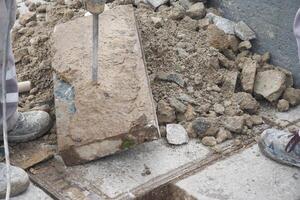 Using a hammer to break through bedrock for landscaping event photo