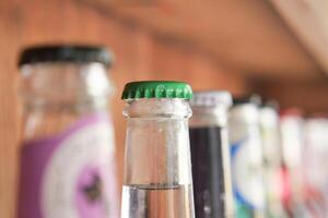 Vintage beverage bottles with colorful caps on bar shelf create a nostalgic retro drinks display photo