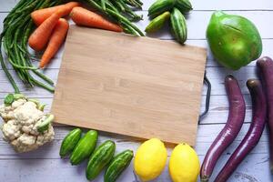 high angle view of chopping board and vegetables on table. photo