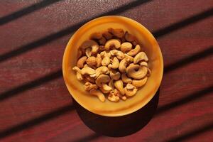 close up of cashew nut in a bowl on table . photo