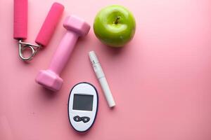 blood sugar measurement for diabetes with apple and dumbbell photo
