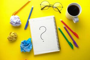 high angle view of question mark on notepad photo