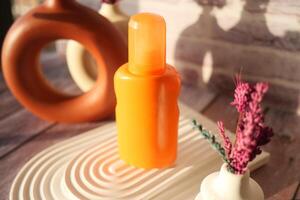 Close up of sunscreen cream ion orange color background photo