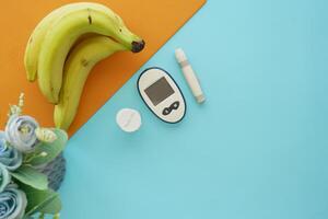 diabetic measurement tools and banana on a color background photo