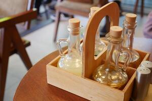 Wooden tray with condiment bottles on table in cozy cafe, creating warm inviting atmosphere photo