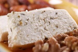 A detailed view of freshly served feta cheese complemented with walnuts on a plate photo