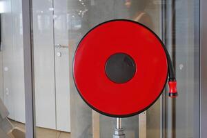 A red fire hose reel is installed in a modern building, emphasizing safety and emergency readiness photo