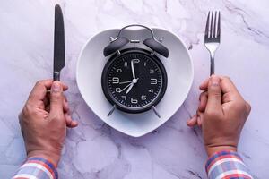 high angle view of clock on plate on wooden table. photo