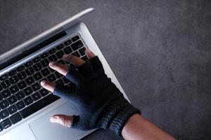 hacker hand stealing data from laptop, high angel view photo